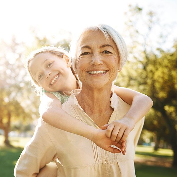 Elder woman with young girl on her back