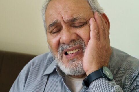 An old patient suffering from peeling gums around a tooth in Scottsdale, AZ.