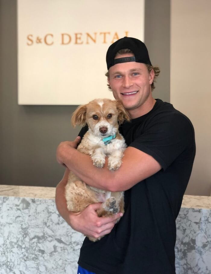 S&C Dental's cheerful patient at Scottsdale clinic, hugging his pet dog