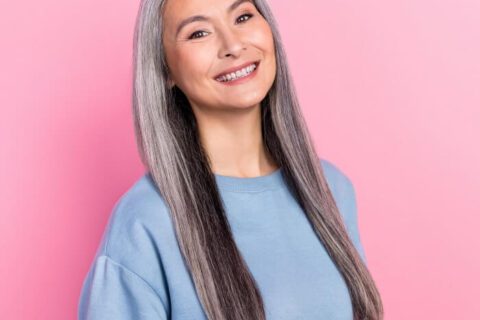 Smiling older woman showing off her ceramic dental implants at S&C Dental in Scottsdale, AZ
