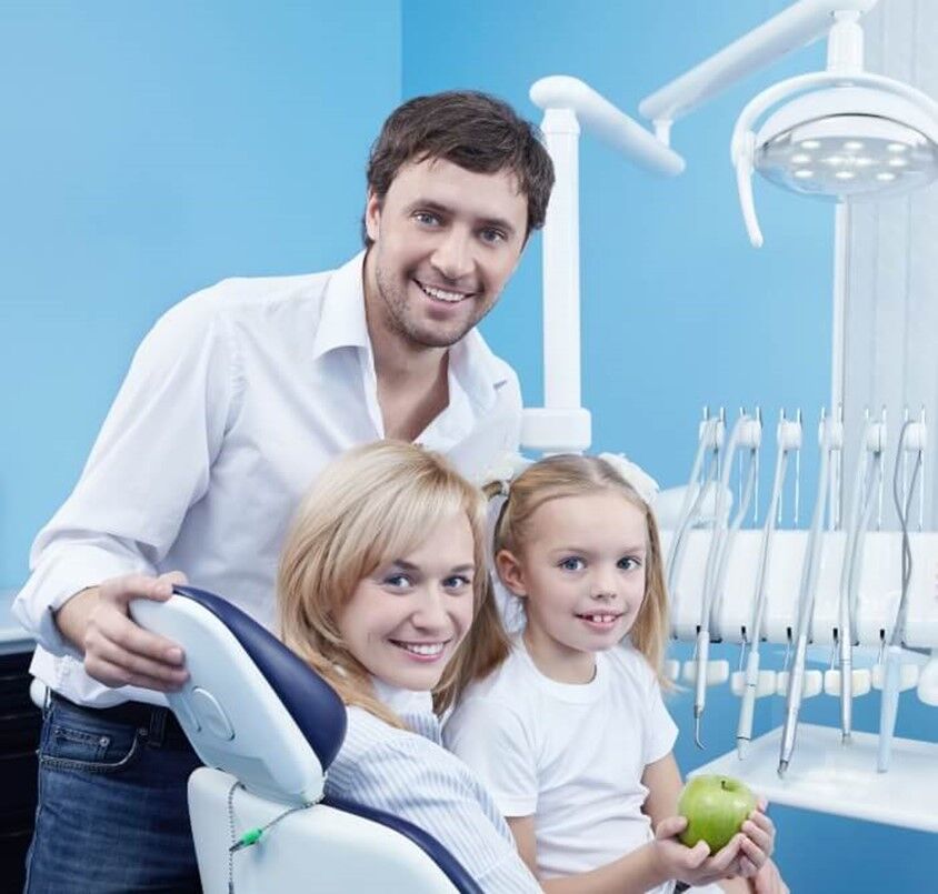 A woman and her child sitting in a dental chair