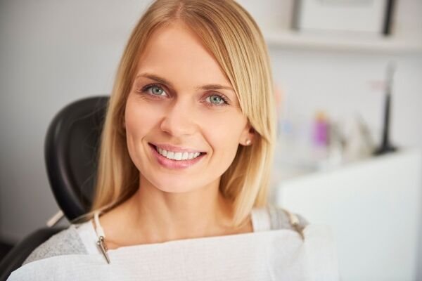 Portrait of smiling woman in dentist's clinic after getting inlays