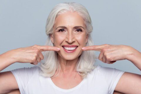 A woman showing the after results of her dental implants in Scottsdale, AZ.